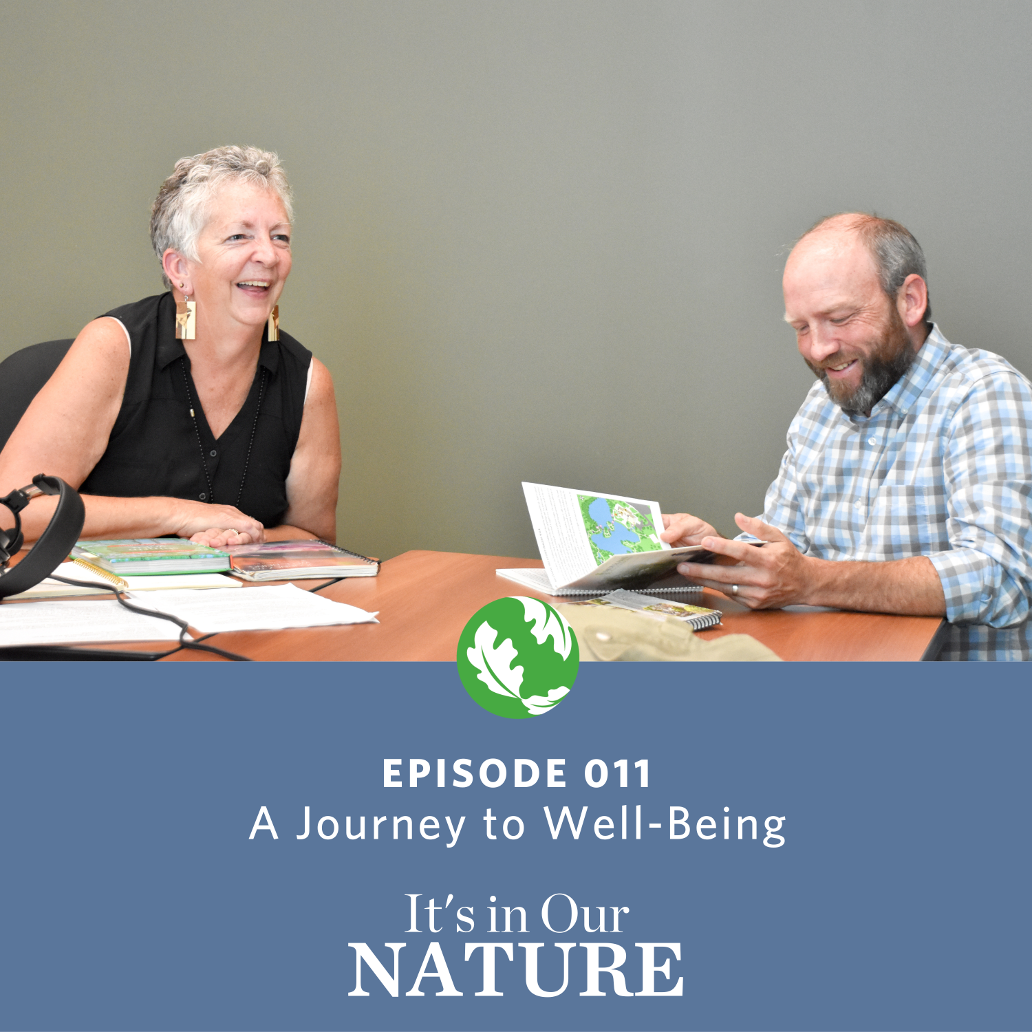 A man and a woman sitting at table laughing as they talk.