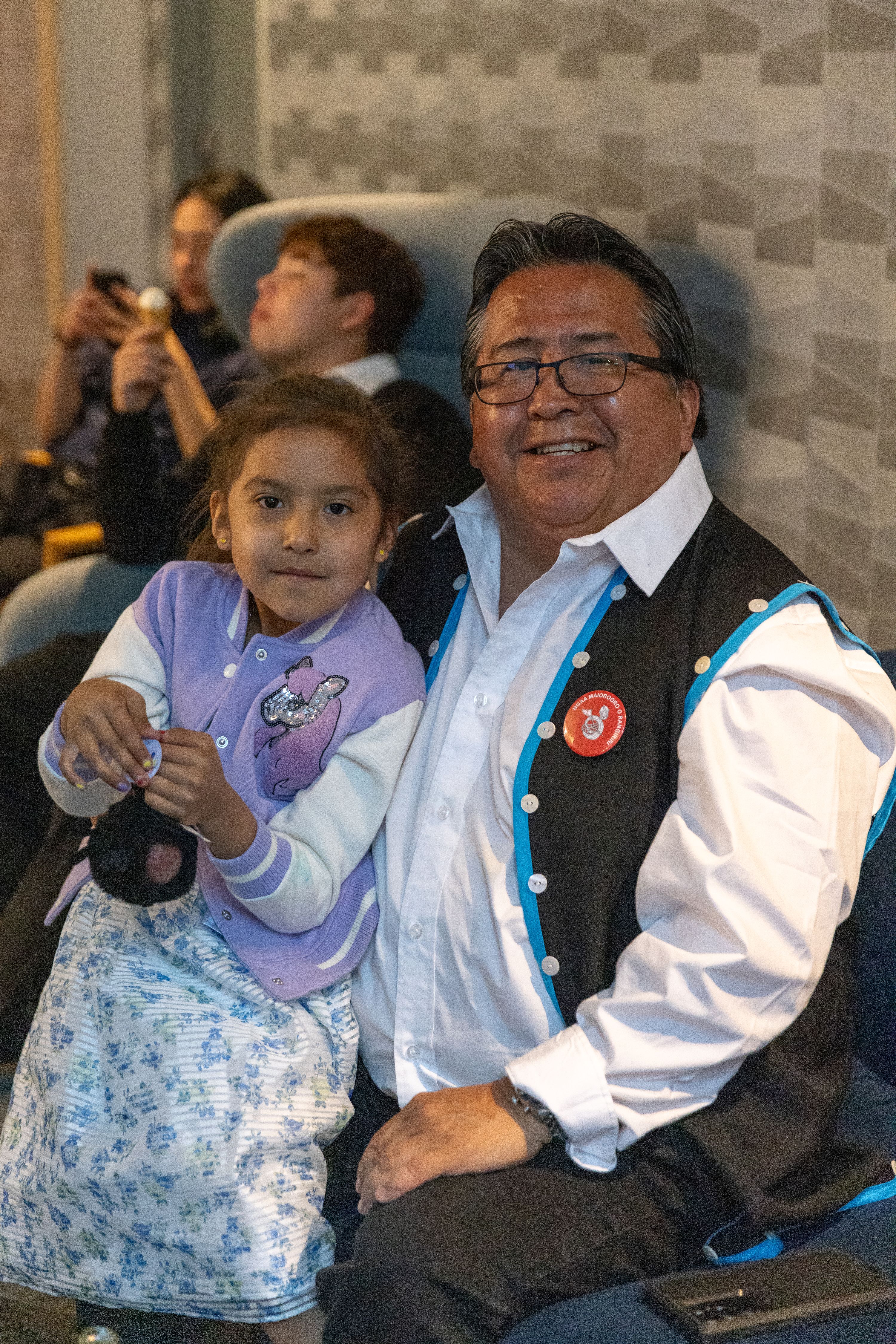 A person sits with a young child.