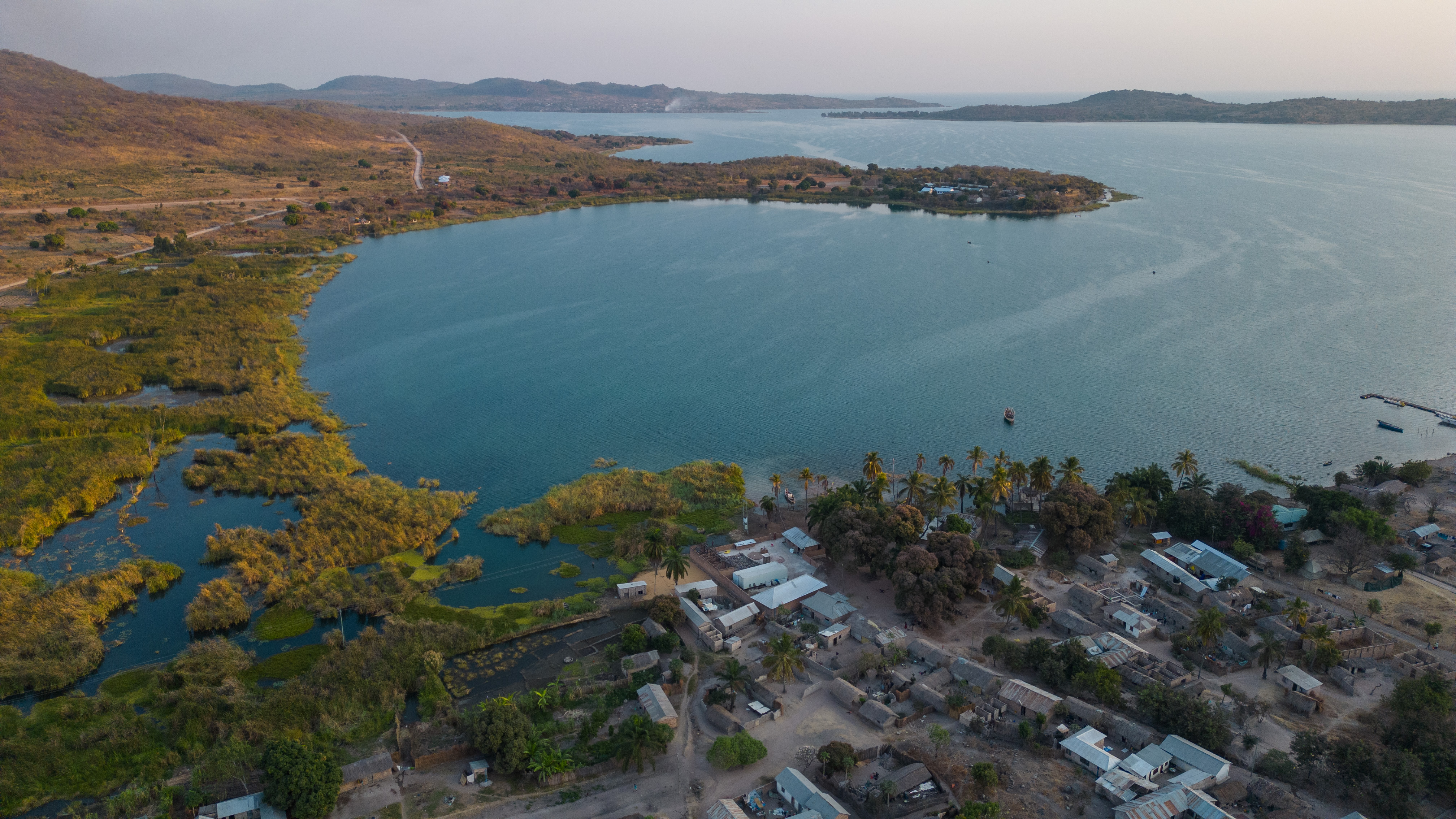 An aerial view of a lake with a village to the side.