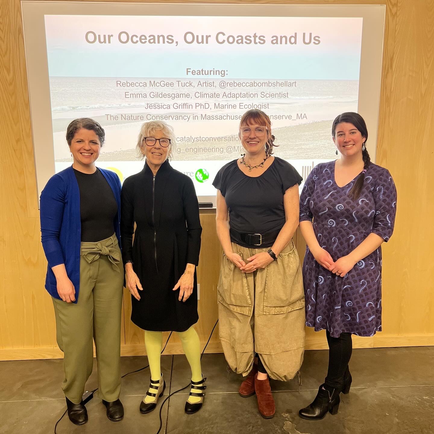 Four speaker stand in front of a title slide that reads "Our Oceans, Our Coasts and Us."
