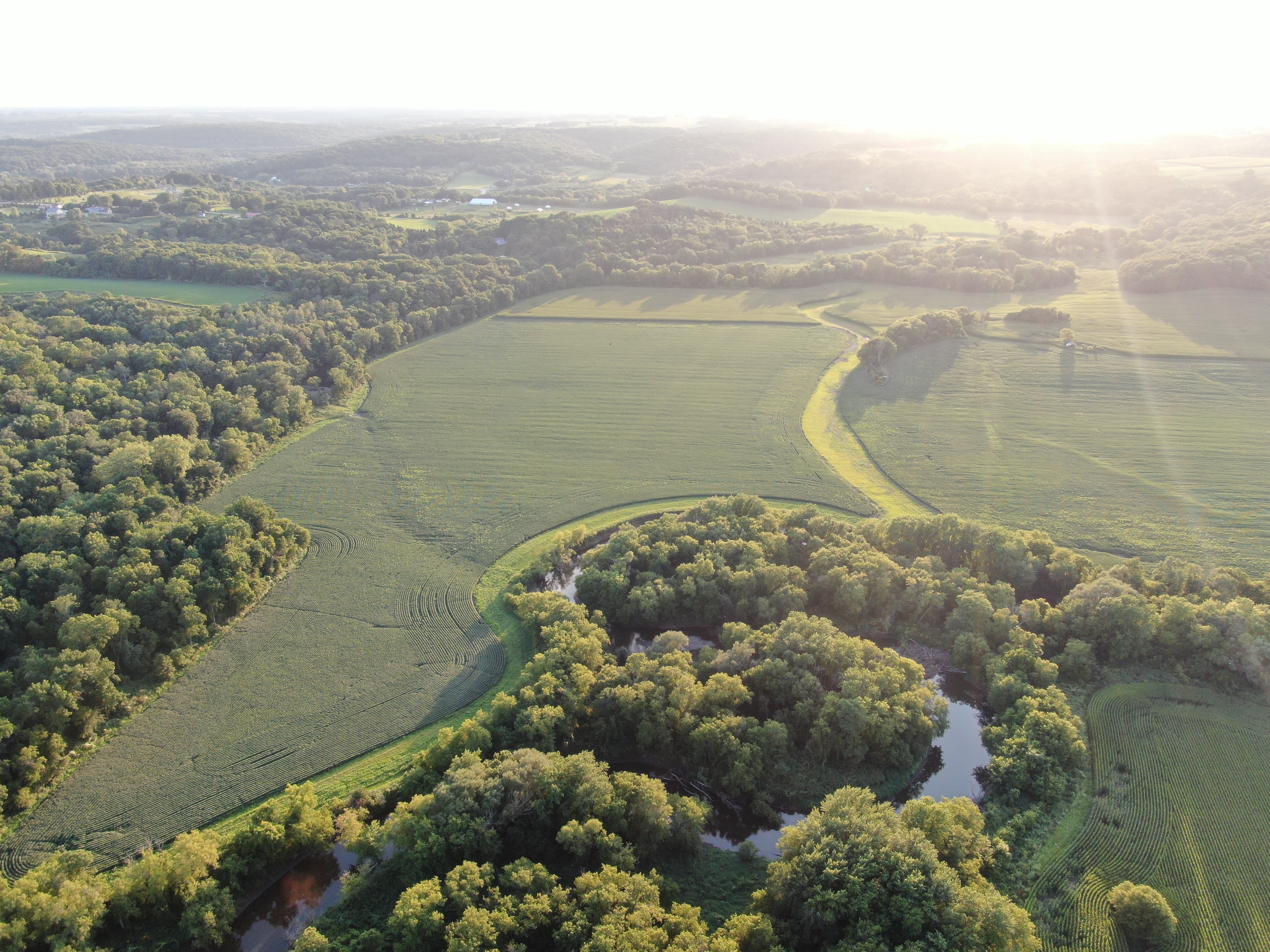 Aerial view of a river meandering through crop fields.