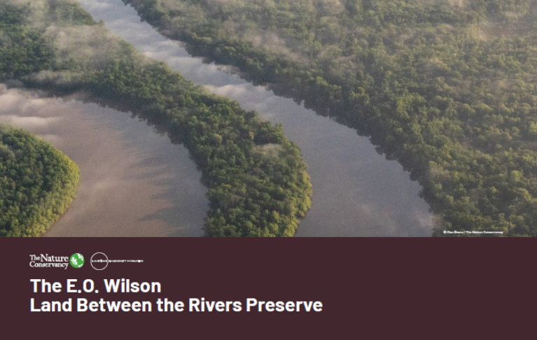The cover of a brochure features an aerial view of a river and forest.