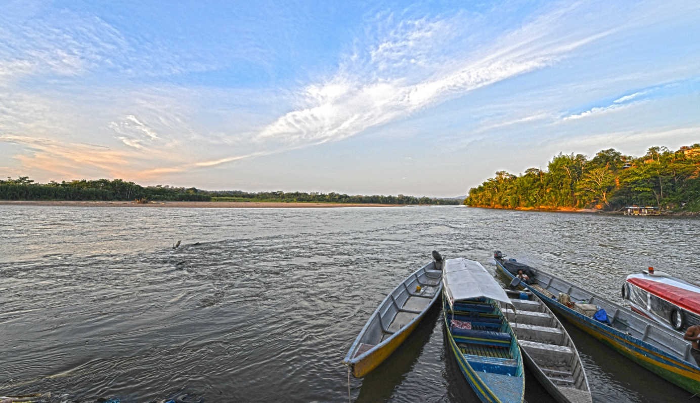 Vista desde una canoa sobre un rio en el atardecer.
