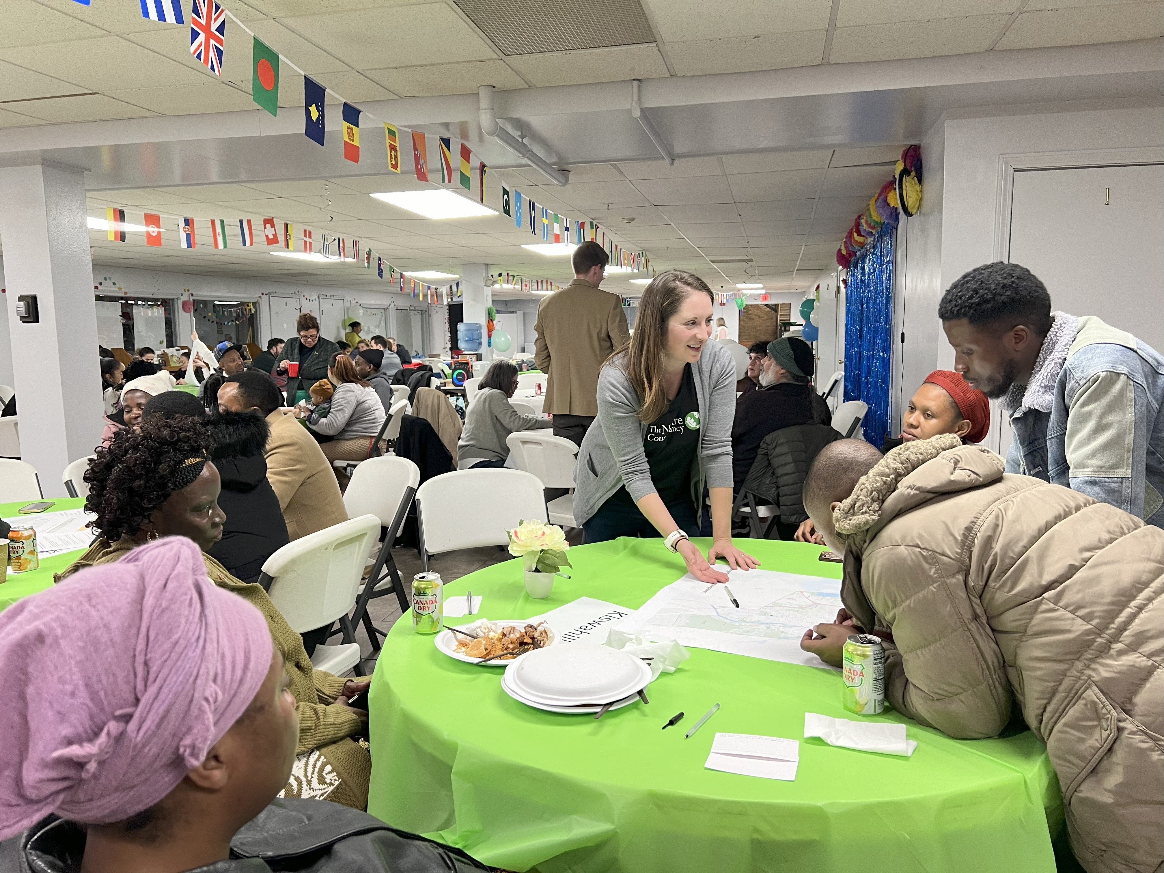 Community members look over a series of maps on a table together.