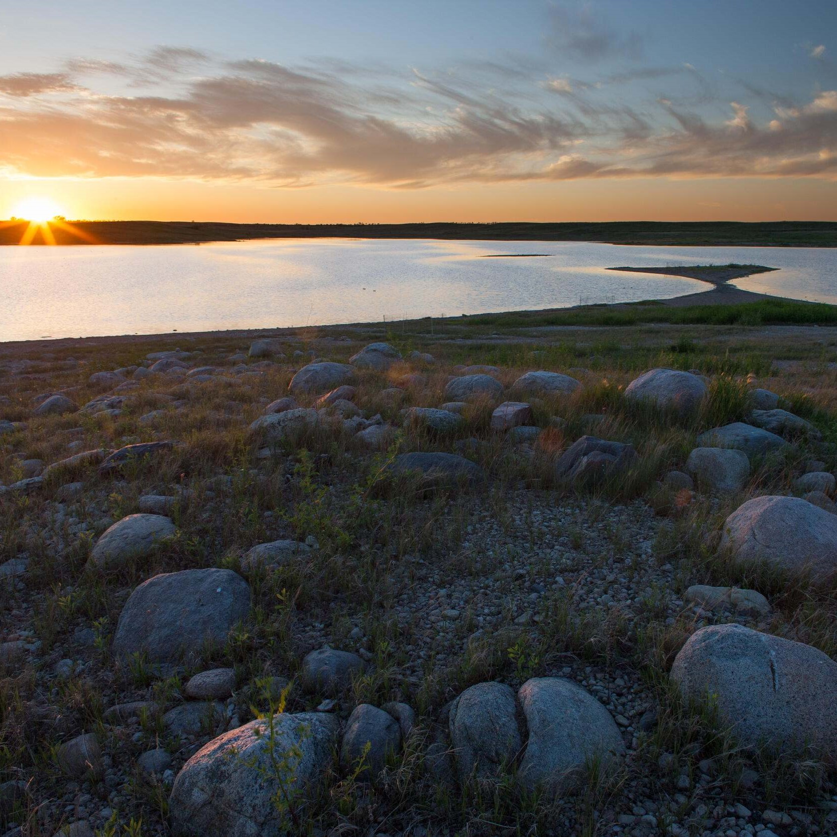 A sun sets over a lake.