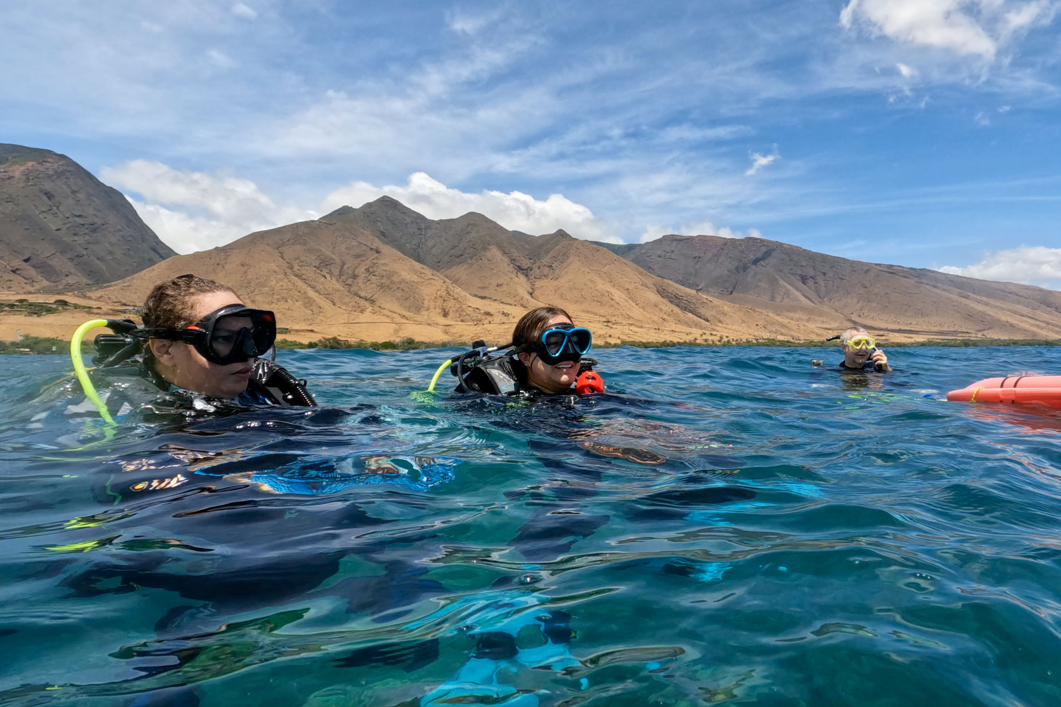 Women divers emerge to the surface of the water. 