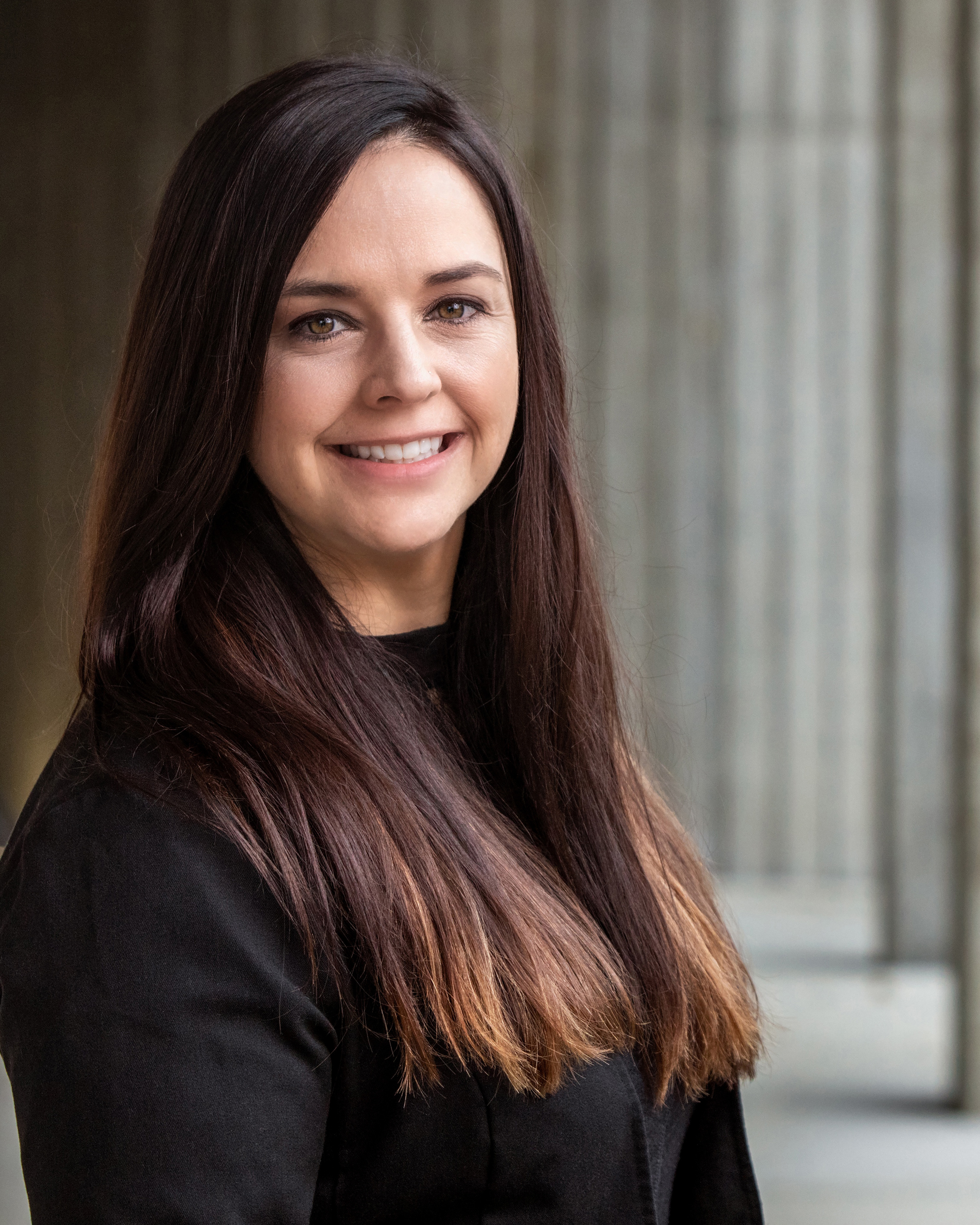 Woman with long brown hair smiling.